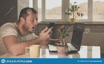 surprised-message-phone-guy-sitting-laptop-kitchen-man-drinking-tea-table-cup-179572153.jpg